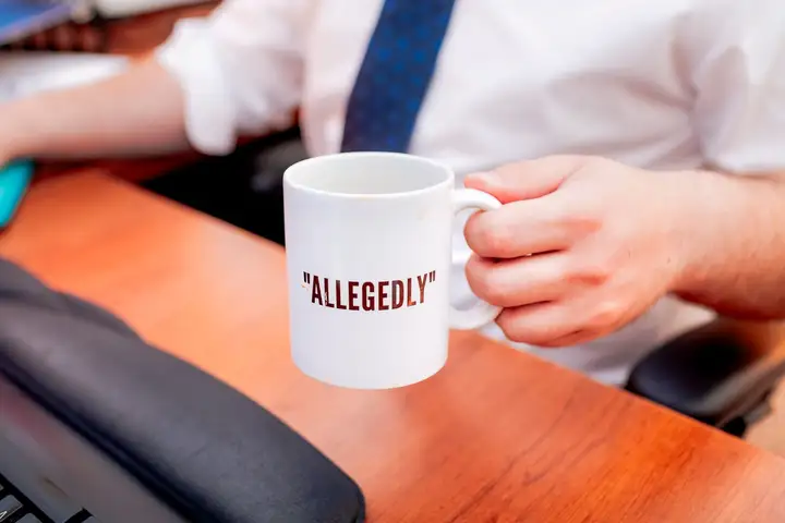 A mug reading 'allegedly' on a desk in the firm's Moncton office